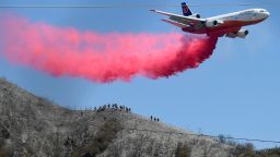 A DC-10 tanker makes a fire retardant drop as hand crews watch from below near Lytle Creek on Thursday, Aug. 26, 2021 as fire efforts continue to stop the South fire. 18 structures have been destroyed and 700 acres have burned in the fire which started Wednesday afternoon.