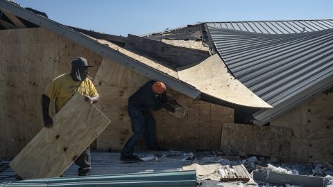 People are working to seal the openings of a damaged bar in Lake Charles, Louisiana, after Hurricane Delta made landfall as a Category 2 storm.