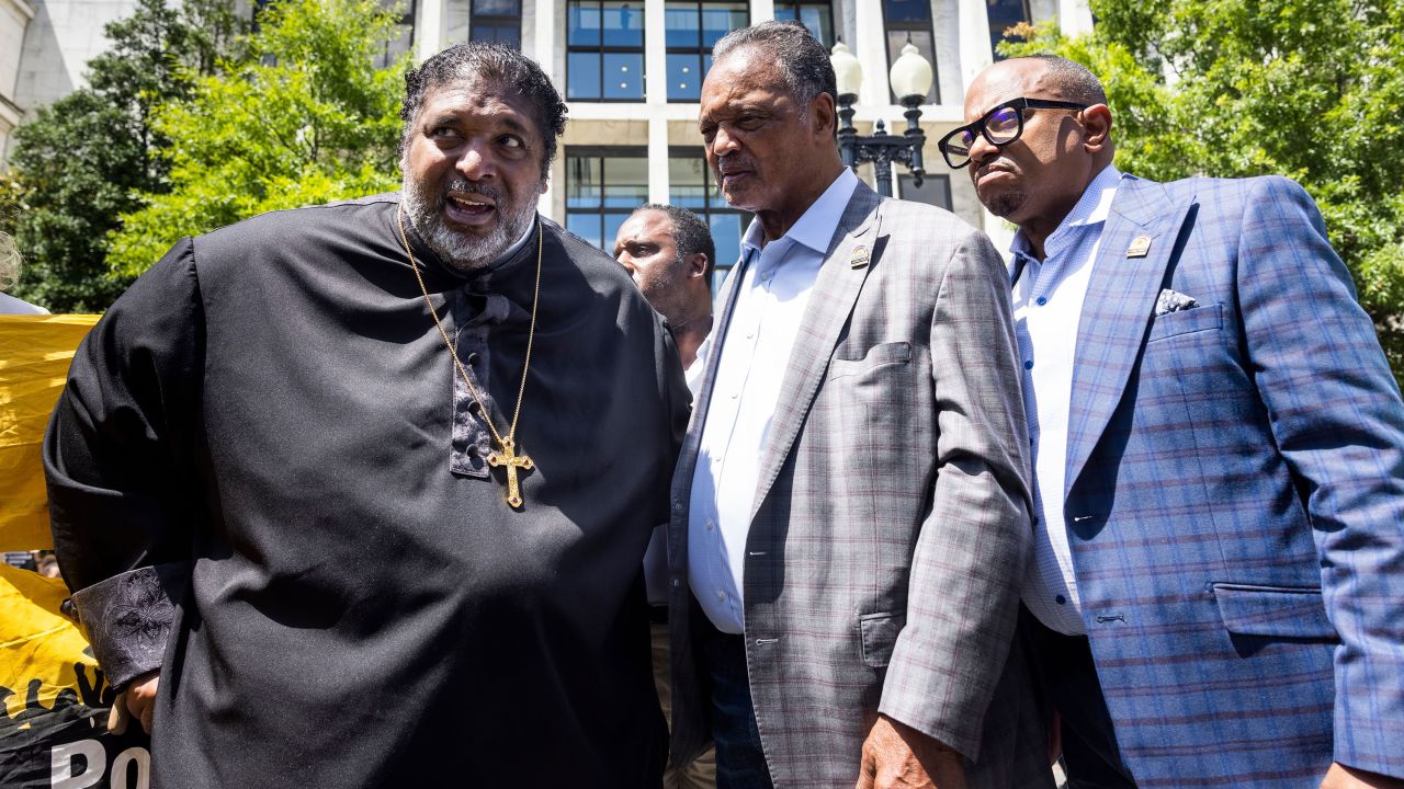 Political activists Reverend William J. Barber II (L) and Reverend Jesse Jackson (C) speak prior to being detained for obstructing traffic during a "Moral March on Manchin and McConnell" in Washington, DC, on June 23, 2021.