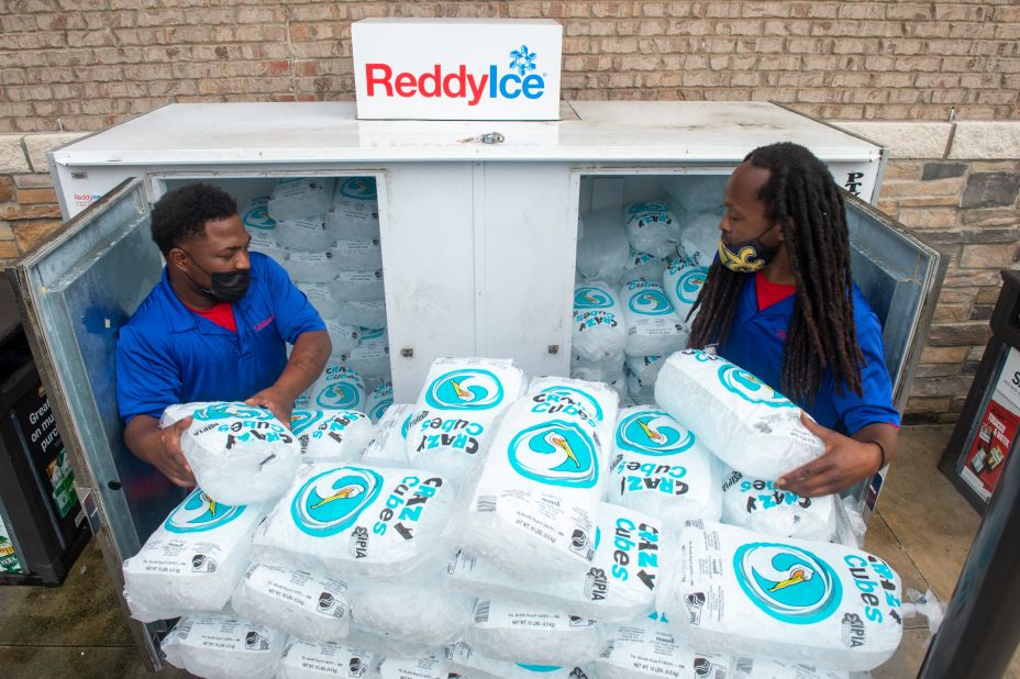 Workers stack bags of ice into a gas station freezer in Jefferson, Louisiana, on August 27.