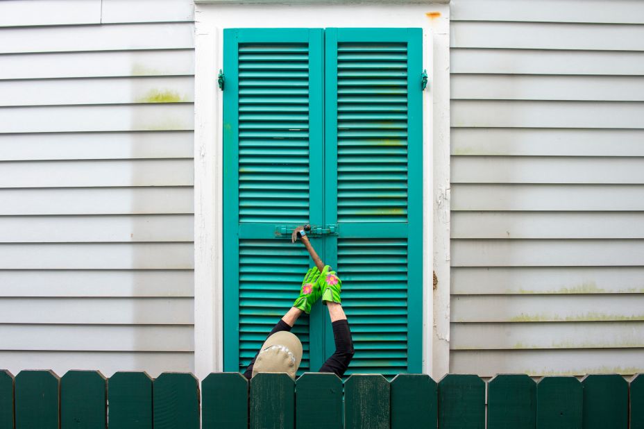 A resident hammers the shutters of a 100-year-old house in New Orleans on August 27.