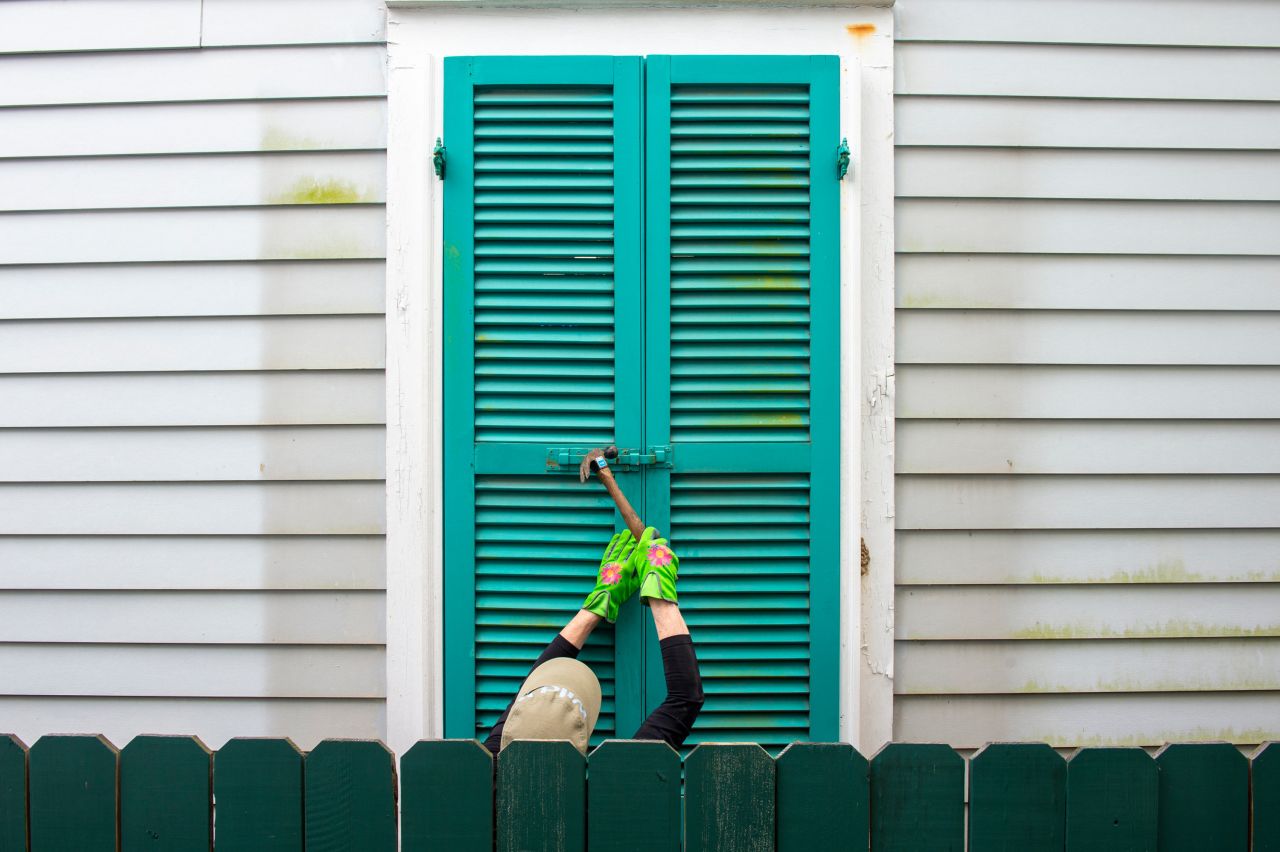 A resident hammers the shutters of a 100-year-old house in New Orleans on August 27.