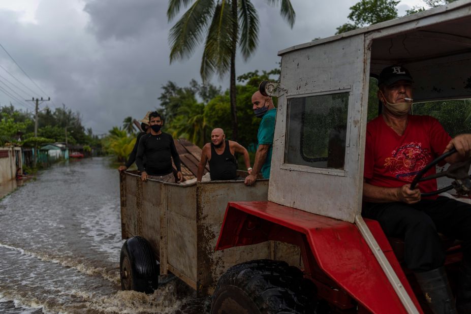 A man drives a tractor through a flooded street in Guanimar, Cuba, on August 28. Before entering the Gulf, Ida made landfall twice over Cuba as a Category 1 hurricane.