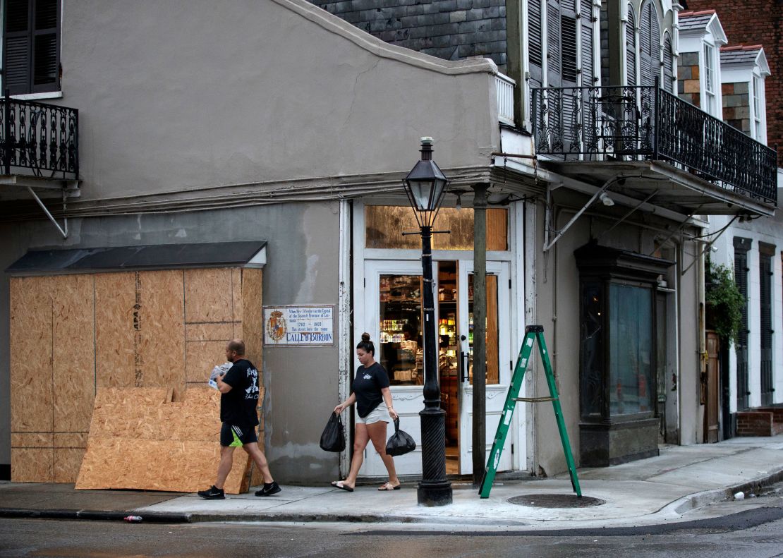 French Quarter residents gather last-minute water and food from the Quarter Master store on Bourbon Street before the store closes ahead of Hurricane Ida in New Orleans, Sunday, August 29, 2021.