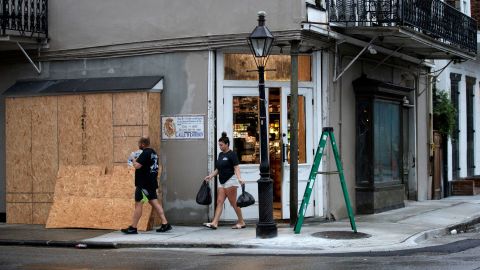 French Quarter residents gather last-minute water and food from the Quarter Master store on Bourbon Street before the store closes ahead of Hurricane Ida in New Orleans, Sunday, August 29, 2021.