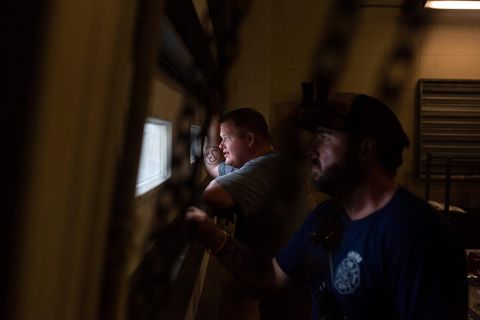 Firefighters look out the window of a shelter in Bourg on August 29.