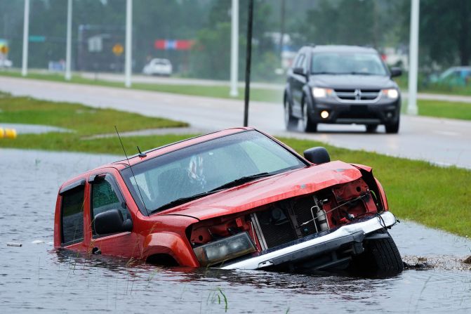 A vehicle is abandoned in a flooded ditch next to a highway in Bay Saint Louis, Mississippi.