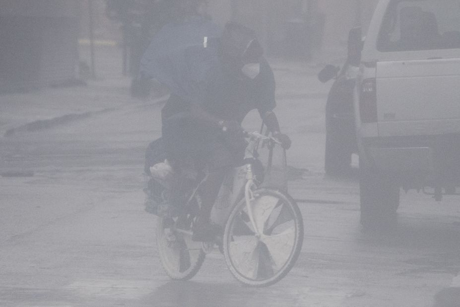 A cyclist wears a face mask while riding through the rain and high winds in New Orleans on August 29.