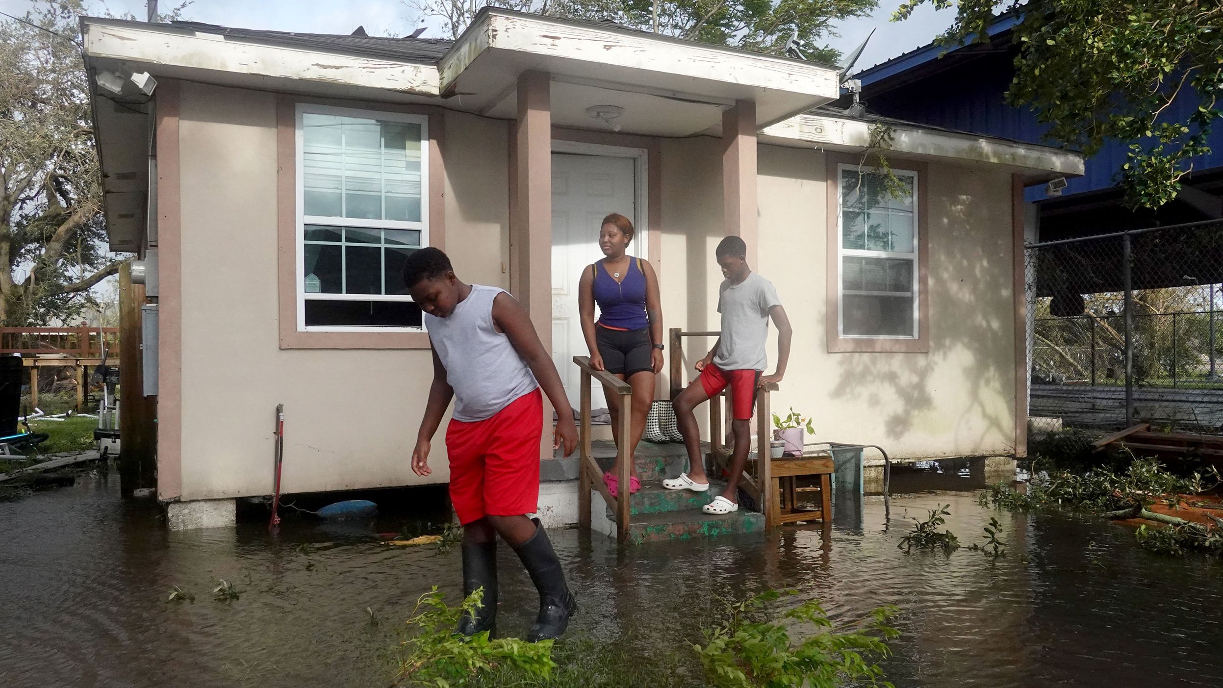 Michelle Washington and her sons Kendrick and Kayden check out damage to their home caused by Hurricane Ida on August 30 in New Orleans.