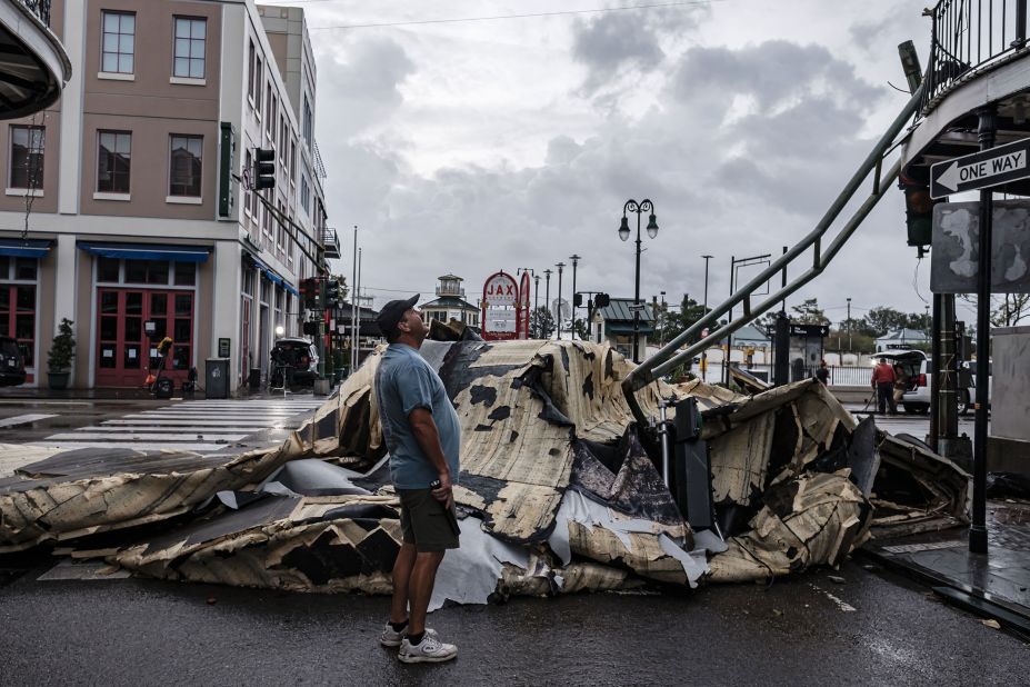 A man looks up next to a section of roof that was ripped off a building in the French Quarter of New Orleans on August 30.