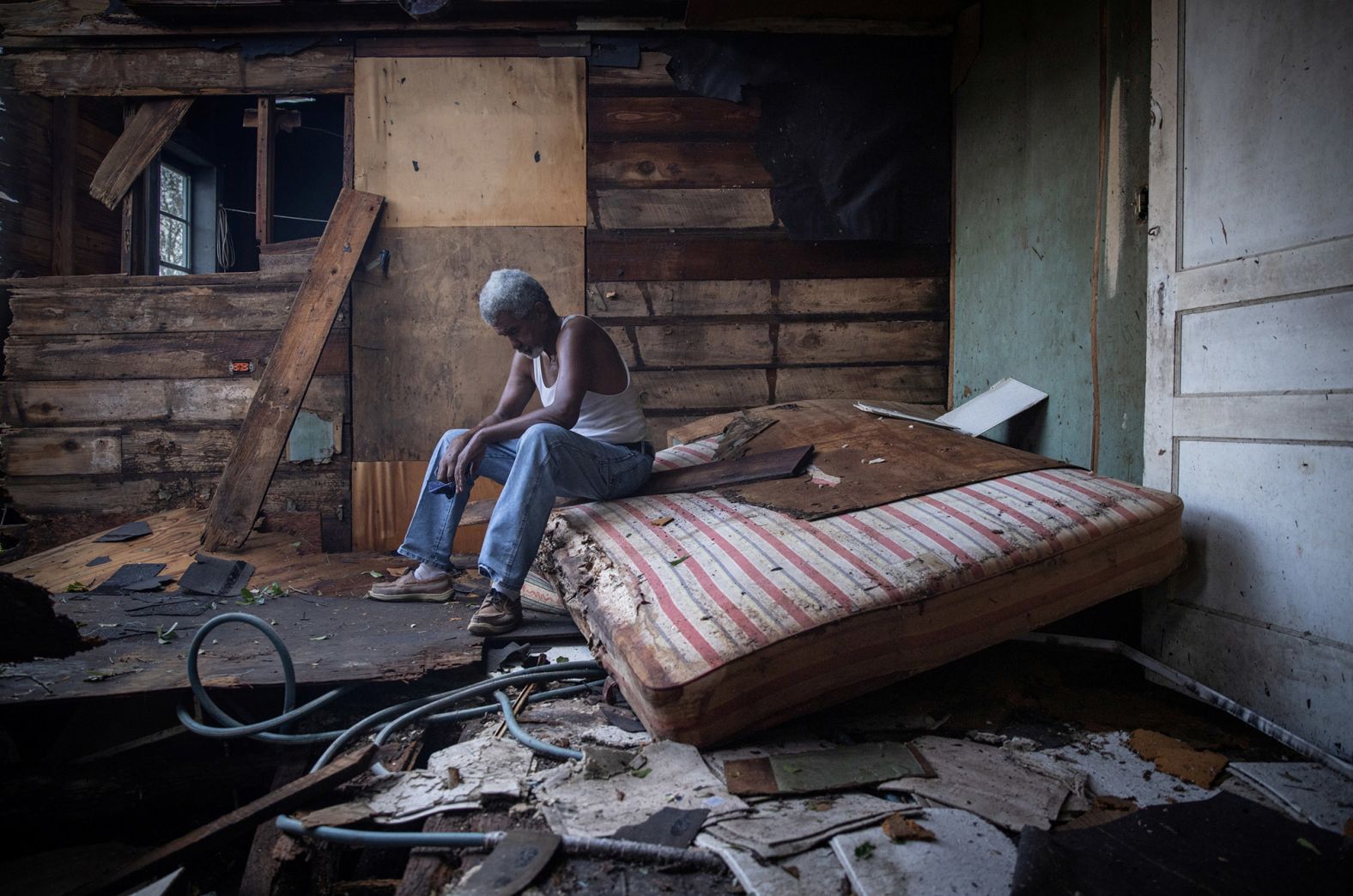 Theophilus Charles sits inside his damaged home in Houma on August 30.