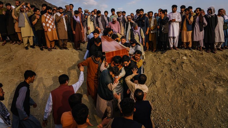 A casket is brought to a grave site at a mass funeral in Kabul on August 30. <a href="index.php?page=&url=https%3A%2F%2Fwww.cnn.com%2F2021%2F08%2F29%2Fasia%2Fafghanistan-kabul-evacuation-intl%2Findex.html" target="_blank">Ten members of one family</a> — including seven children — were dead after a US drone strike targeted a vehicle in a residential neighborhood of Kabul, a relative of the dead told CNN. The United States carried out what it called a defensive airstrike in Kabul, targeting a suspected ISIS-K suicide bomber who posed an "imminent" threat to the airport, US Central Command said. The Pentagon has said the strike resulted in secondary explosions and that those explosions may have been what killed the civilians.