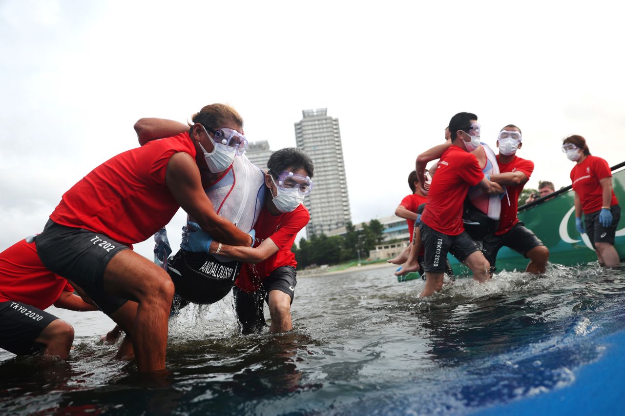 Athletes are helped out of the water during a triathlon on August 29.