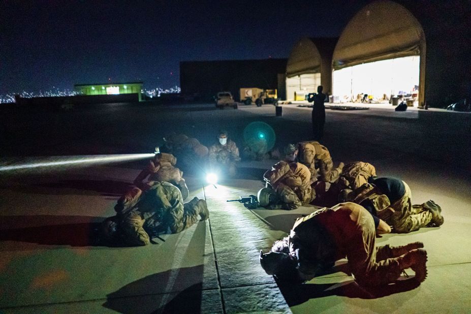 Taliban fighters bow in prayer on August 31 after they secured the Kabul airport and inspected the equipment that was left behind.