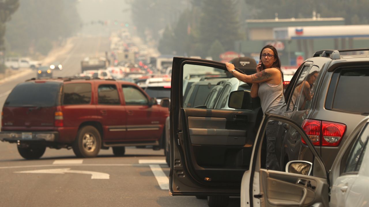 A woman talks on her phone while stopped in heavy traffic on Hwy 50 as people evacuate ahead of the Caldor Fire on August 30, 2021, in South Lake Tahoe, California.