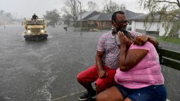 People react as a sudden rain shower soaks them with water while riding out of a flooded neighborhood in a volunteer high water truck assisting people evacuating from homes after neighborhoods flooded in LaPlace, Louisiana on August 30, 2021 in the aftermath of Hurricane Ida. - Rescuers on Monday combed through the "catastrophic" damage Hurricane Ida did to Louisiana, a day after the fierce storm killed at least two people, stranded others in rising floodwaters and sheared the roofs off homes. (Photo by Patrick T. FALLON / AFP) (Photo by PATRICK T. FALLON/AFP via Getty Images)