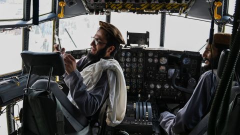 Taliban fighters sit in the cockpit of an Afghan Air Force aircraft at the airport in Kabul on August 31.