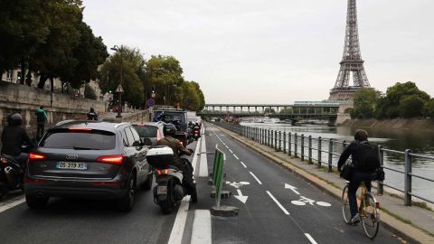 A cyclists rides by congested traffic along the Seine River in Paris.