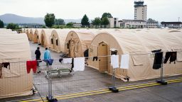 30 August 2021, Rhineland-Palatinate, Ramstein-Miesenbach: People evacuated from Afghanistan stand between tents at Ramstein Air Base.  The US also uses its military base in Ramstein, Palatinate, as a hub for the evacuation of people seeking protection and local forces from Afghanistan. Photo: Uwe Anspach/dpa (Photo by Uwe Anspach/picture alliance via Getty Images)