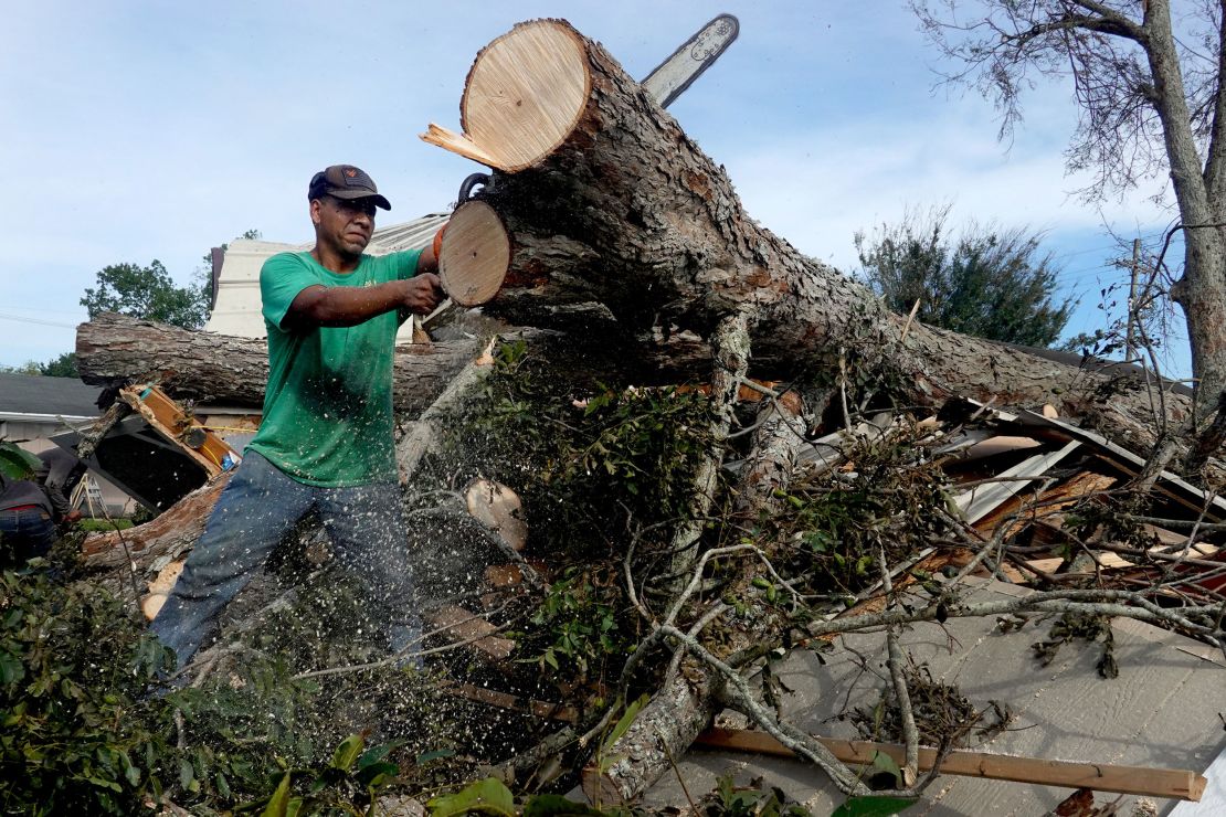 Workers remove a tree that fell on a home during Hurricane Ida on August 31 in Houma, Louisiana.