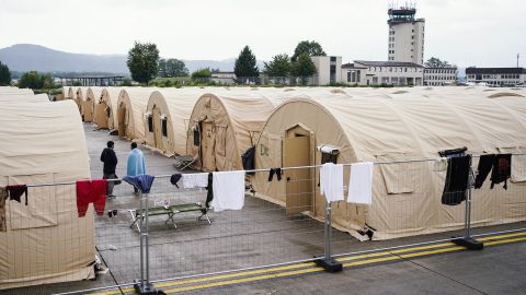 People evacuated from Afghanistan stand between tents at Ramstein.