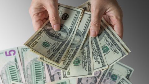 cash in hands with money underneath