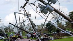 Crews begin work on downed power lines leading to a fire station, Tuesday, Aug. 31, 2021, in Waggaman, La., as residents try to recover from the effects of Hurricane Ida.
