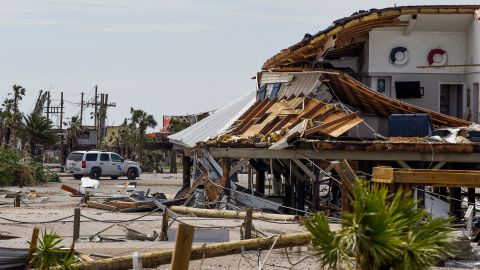 A Louisiana State Trooper keeps watch over damaged homes on Grand Isle on Tuesday.