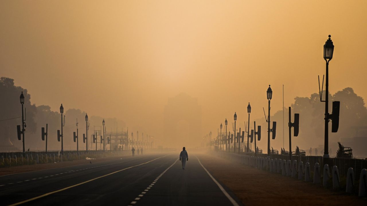 A man walks along Rajpath amid smoggy conditions in New Delhi on January 28, 2021. Air pollution is shaving nearly six years off people's lives in the country, on average.  