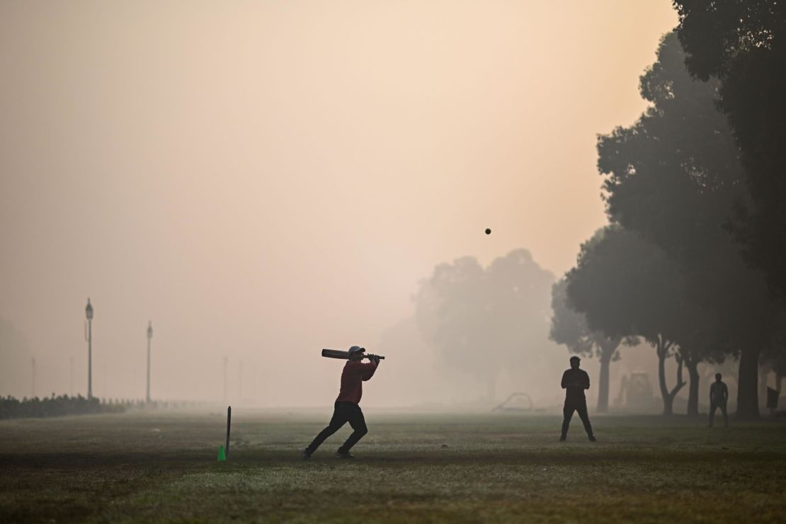 People playing cricket at a park in smoggy conditions in New Delhi on February 8, 2021. 