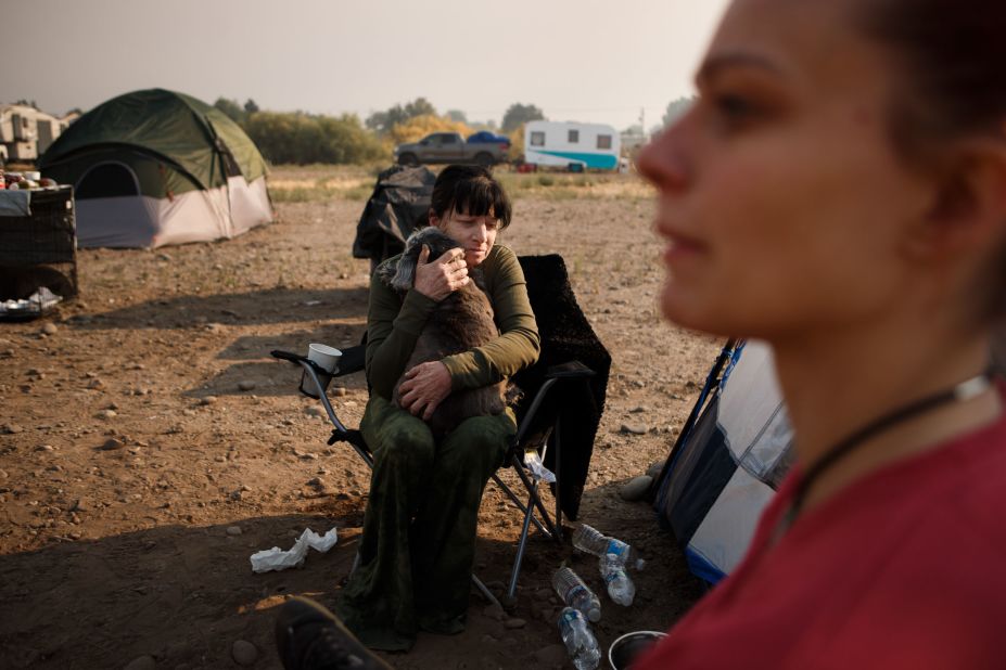 Veronica Foster, an evacuee from South Lake Tahoe, California, hugs her dog, Gracie, as she and her co-workers gather outside an evacuation center in Gardnerville, Nevada, on August 31. The governors of California and Nevada declared states of emergency as <a href="https://www.cnn.com/2021/08/31/weather/western-wildfires-tuesday/index.html" target="_blank">the fast-moving Caldor Fire</a> prompted officials to tell everyone to get out of South Lake Tahoe.