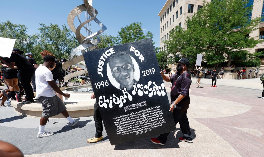 In this June 27, 2020, file photo, demonstrators carry a giant placard during a rally and march over the death of Elijah McClain outside the police department in Aurora, Colorado.