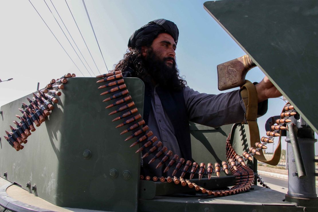 A Taliban fighter parades seized US weaponry through Kandahar.