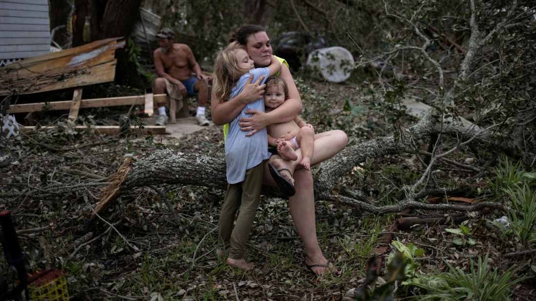 Tiffany Miller embraces her daughter Desilynn, left, and godchild Charleigh after the family returned to their destroyed home in Golden Meadow, Louisiana, on Wednesday, September 1.