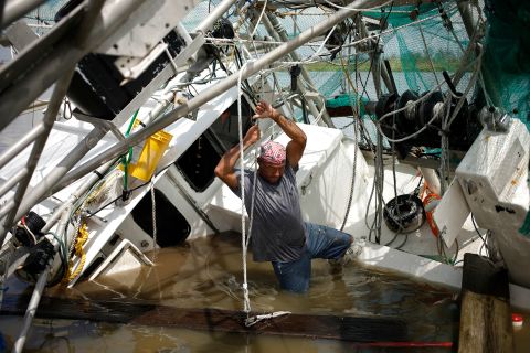 A shrimper works to salvage his partially submerged boat in Golden Meadow on August 31.