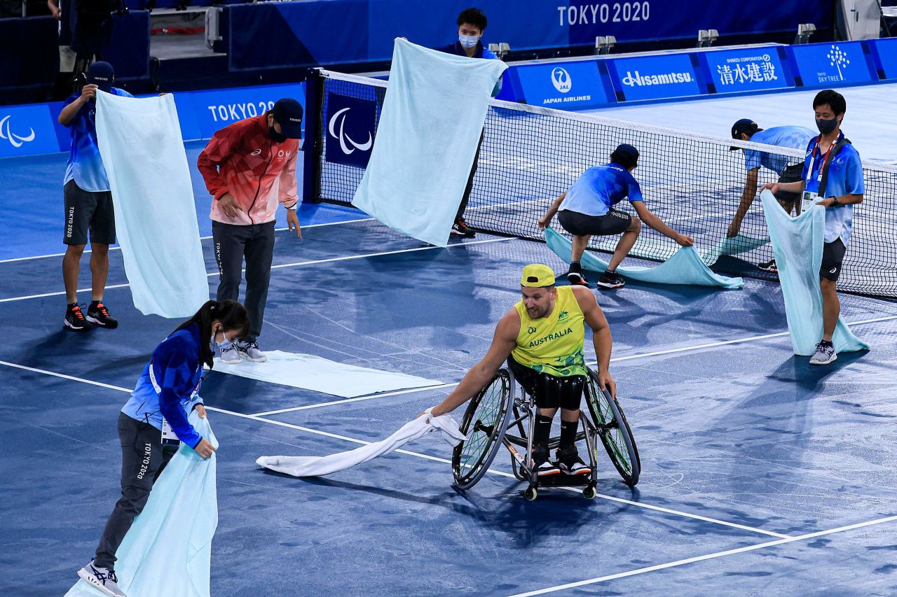 Australia's Dylan Alcott helps volunteers dry the court before his wheelchair tennis match on September 1.