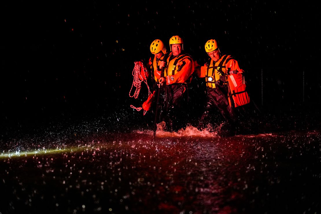 Members of the Weldon Fire Company walk through floodwaters in Dresher, Pennsylvania.