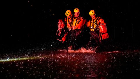 Members of the Weldon Fire Company walk through floodwaters in Dresher, Pennsylvania.