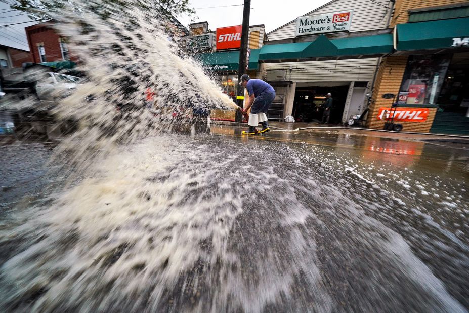 Water is pumped from the basement of a business in Oakdale, Pennsylvania, during cleanup on September 1.