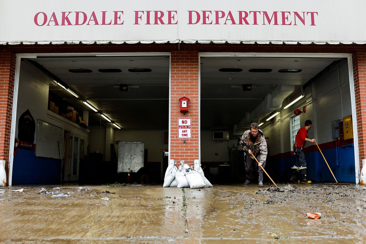 Members of the Oakdale Fire Department clear debris from their station after heavy rains in Oakdale, Pennsylvania, on September 1.
