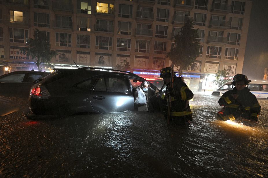 Members of the New York City Fire Department rescue a woman from her stalled car on September 1.