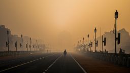 TOPSHOT - A man walks along Rajpath amid smoggy conditions in New Delhi on January 28, 2021. 