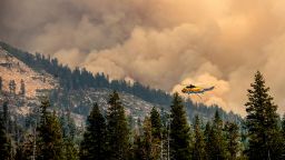 A helicopter flies over Wrights Lake while battling the Caldor Fire in Eldorado National Forest, Calif., on Wednesday, Sept. 1, 2021. 