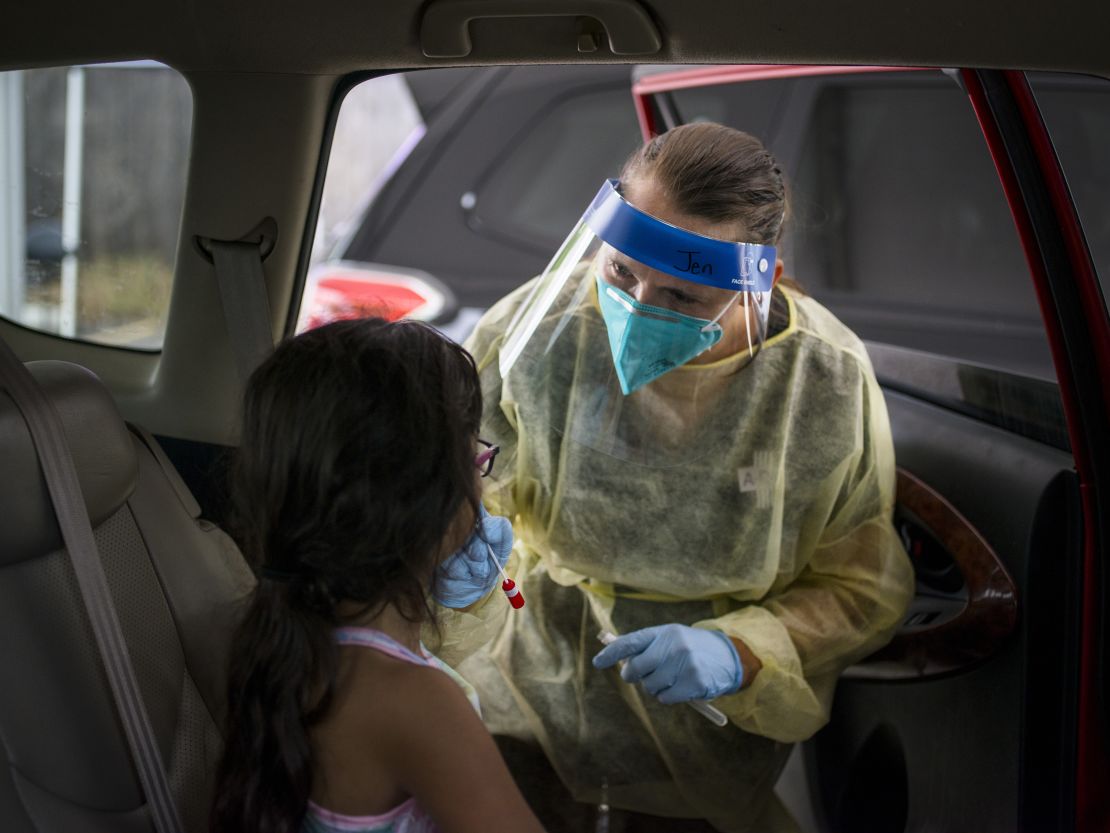 A healthcare worker administers a Covid-19 test to a child at the Austin Regional Clinic drive-thru vaccination and testing site in Austin, Texas, on Thursday, Aug. 5, 2021.