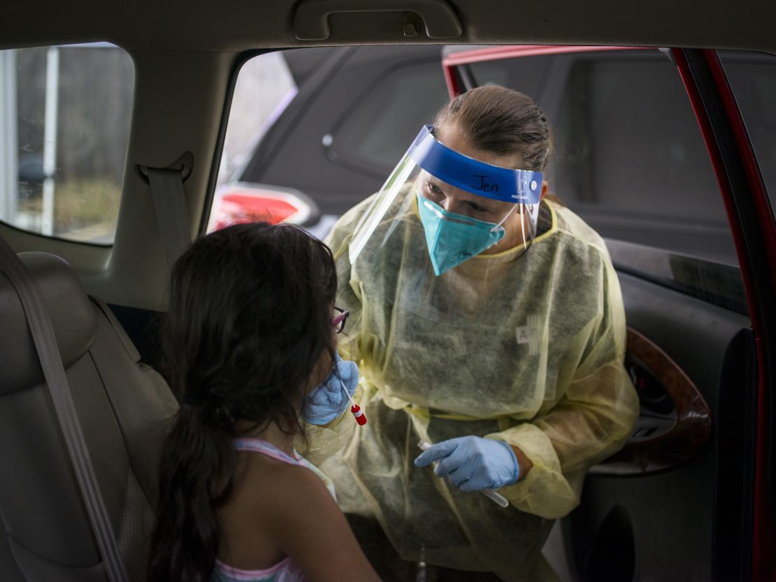 A healthcare worker administers a Covid-19 test to a child at the Austin Regional Clinic drive-thru vaccination and testing site in Austin, Texas, on Thursday, Aug. 5, 2021. 