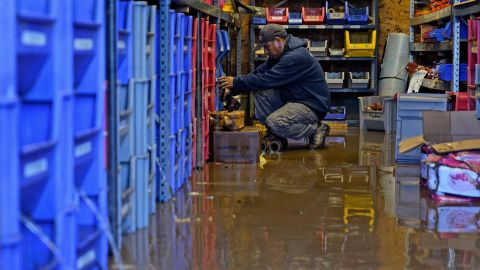 An employee helps clean up after the business he works at was flooded in Woodland Park, New Jersey.