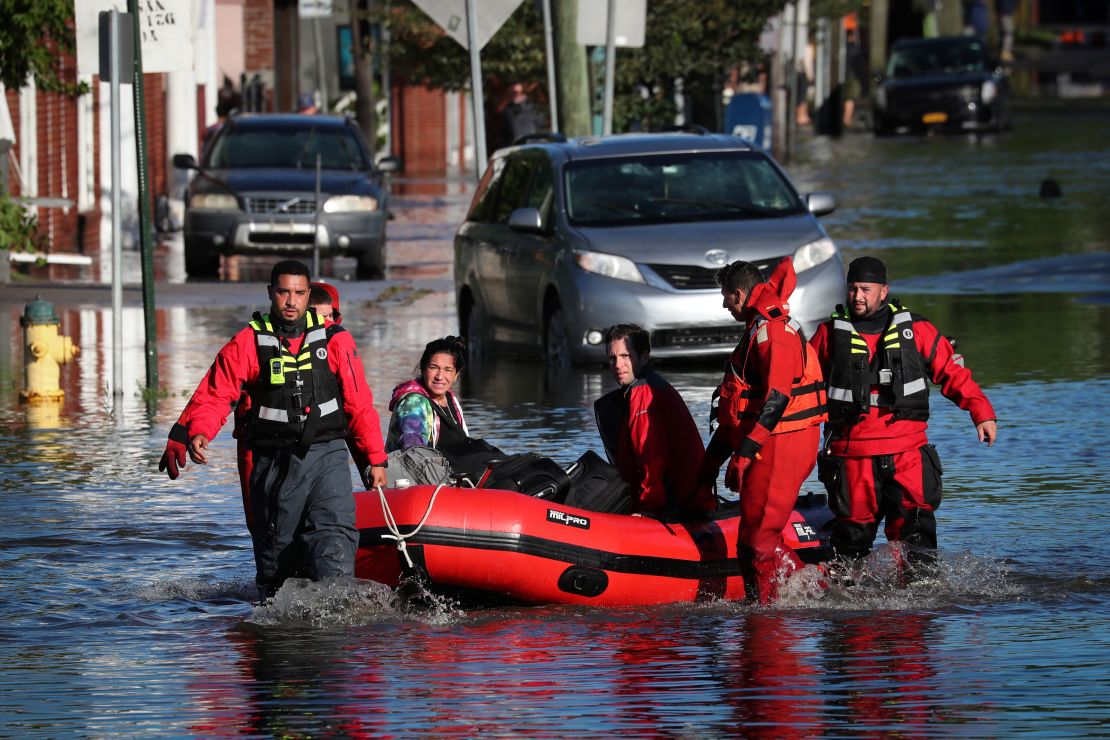 First responders pull local residents in a boat as they perform rescues in Mamaroneck, New York.