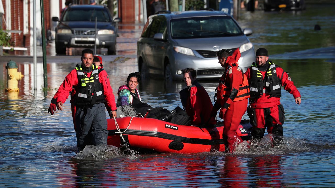 First responders pull local residents in a boat as they perform rescues in Mamaroneck, New York.