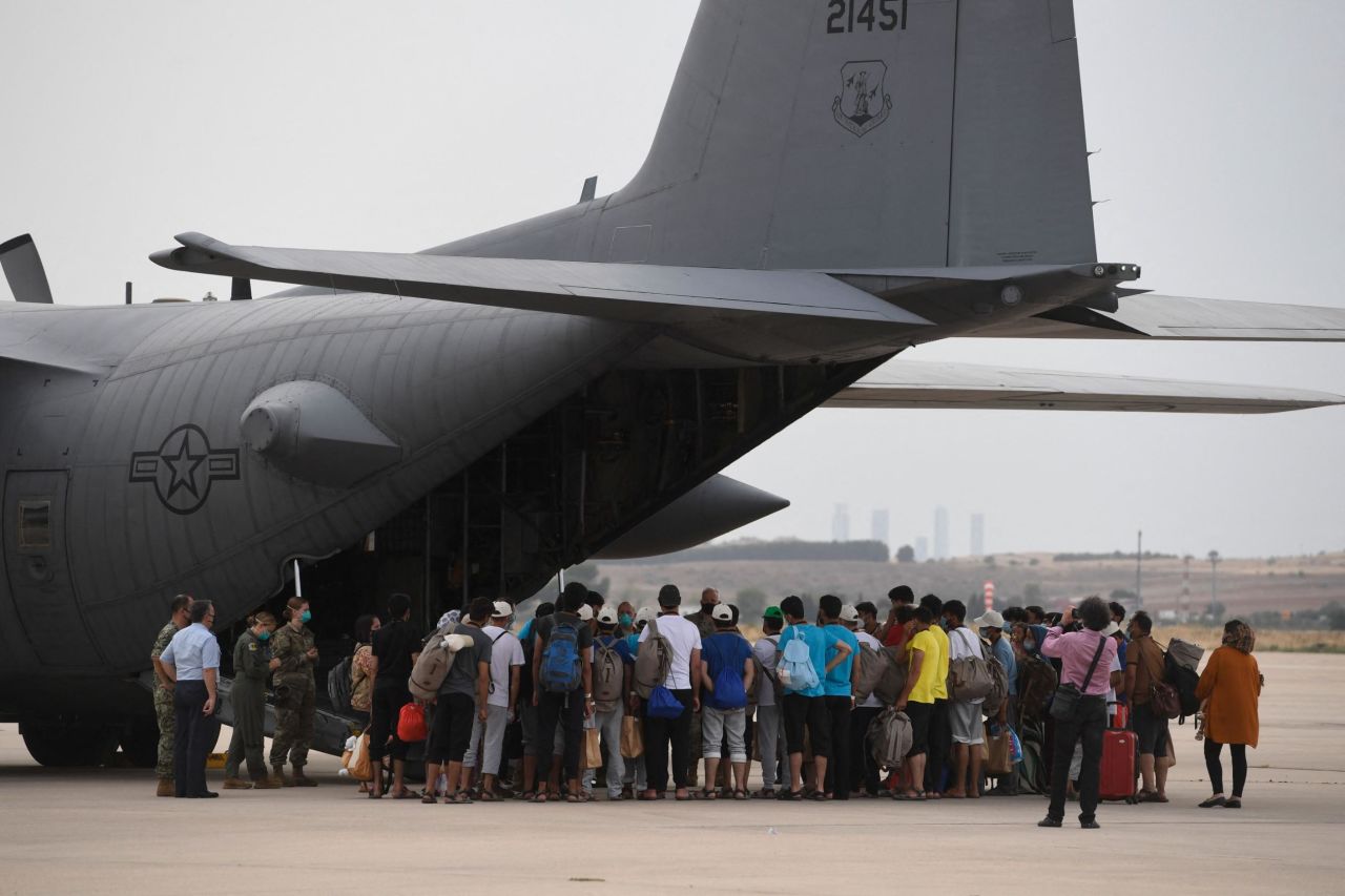 Afghan refugees at an airbase in Madrid, Spain,  board a US aircraft heading to Germany after being evacuated from Kabul on August 24, 2021. 
