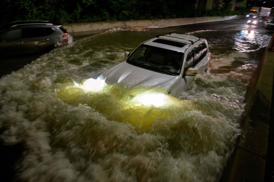 A motorist drives a car through a flooded expressway in Brooklyn, New York.